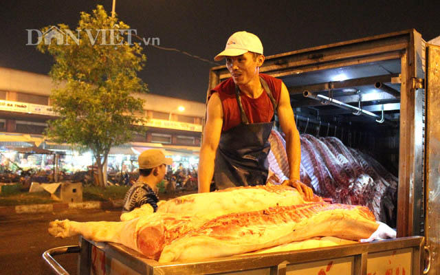 Tiểu thương đang vận chuyển heo mảnh vào khu nhà lồng tại chợ đầu mối Hóc Môn (TP.Hồ Chí Minh). Ảnh: Nguyên Vỹ