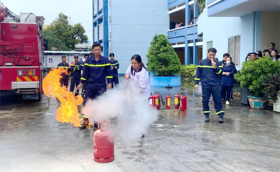Cảnh sát PCCC và CNCH Công an tỉnh Bạc Liêu, hướng dẫn các em học sinh sử dụng bình chữa cháy xách tay để dập lửa.