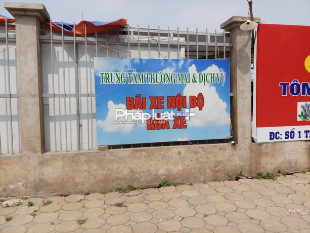 Phía ngoài khu đất được căng biển với dòng chữ" Trung tâm thương mai và dịch vụ bãi xe nội bộ, rửa xe".