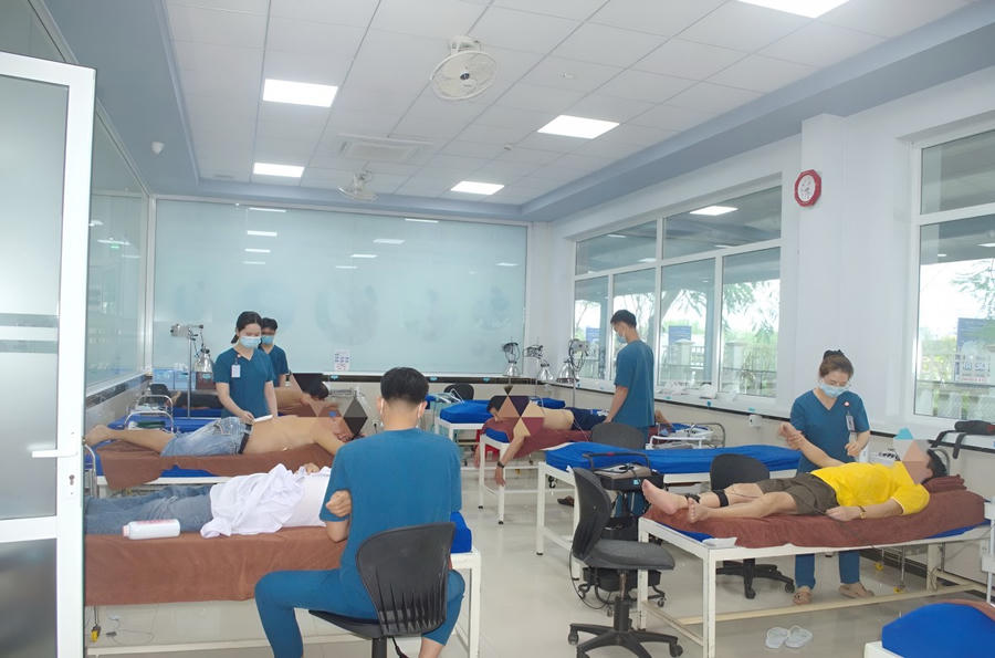 Bác sỹ, kỹ thuật viên, đang điều trị vật lý trị liệu cho bệnh nhân.
