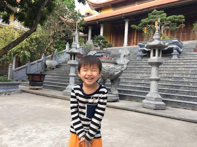 Em bé hồn nhiên chơi trên sân chùa.