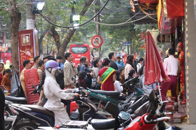 Trên các vỉa hè, tràn ngập xe cộ cùng với đó là sự tấp nập người vào ra để mua vàng cầu may.