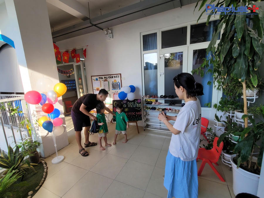 Cha mẹ đưa các con tới trường, chụp ảnh kỷ niệm với các con.