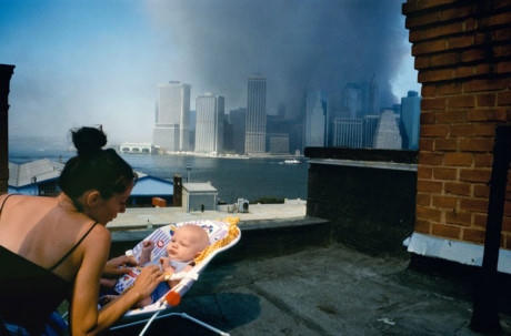 B&agrave; mẹ trẻ dỗ d&agrave;nh con nhỏ tr&ecirc;n tầng m&aacute;i của một ng&ocirc;i nh&agrave; ở Brooklyn trong khi những đ&aacute;m kh&oacute;i đen nghịt tại hiện trường&nbsp;vụ tấn c&ocirc;ng 11/9&nbsp;đang bao tr&ugrave;m bầu trời ở khu Hạ Manhattan.