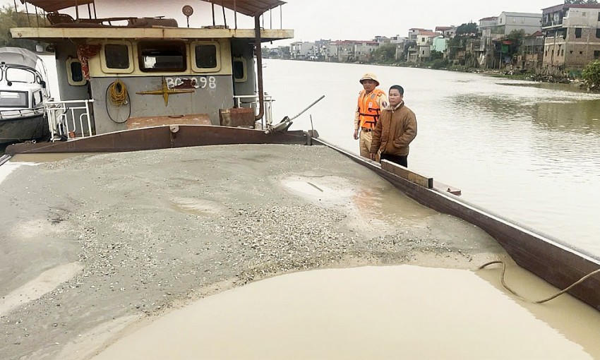 Lực lượng cảnh sát đường thuỷ kiểm tra phương tiện vận chuyển cát trên sông Cầu. (Ảnh: Báo Bắc Giang).