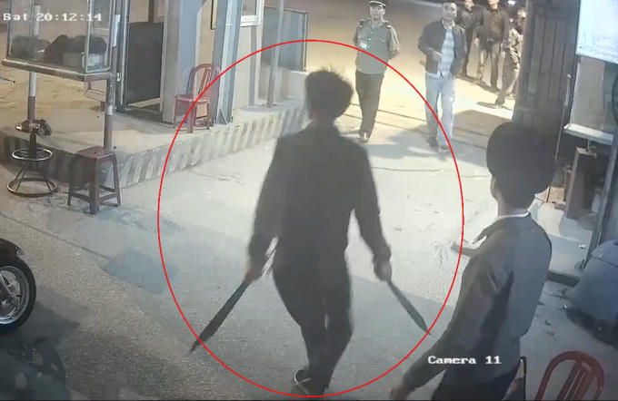 Trên tay đối tượng cầm hai con dao, kiếm dài khiến nhiều người hoảng sợ.