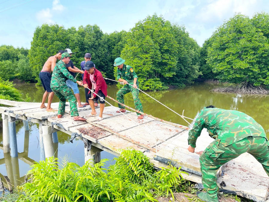 Cán bộ, chiến sĩ Đồn Biên phòng Tam Giang Tây phối hợp cùng địa phương và Nhân dân bắt lại cầu.