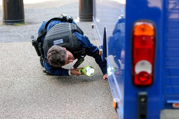 Cảnh sát kiểm tra kĩ càng trước khi cho xe vào bên trong. (Ảnh: Daily Mirror)