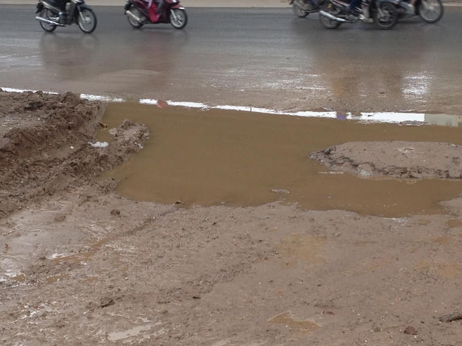 Xe quá tải cày nát còn đường tạo nên những ổ gà lớn.