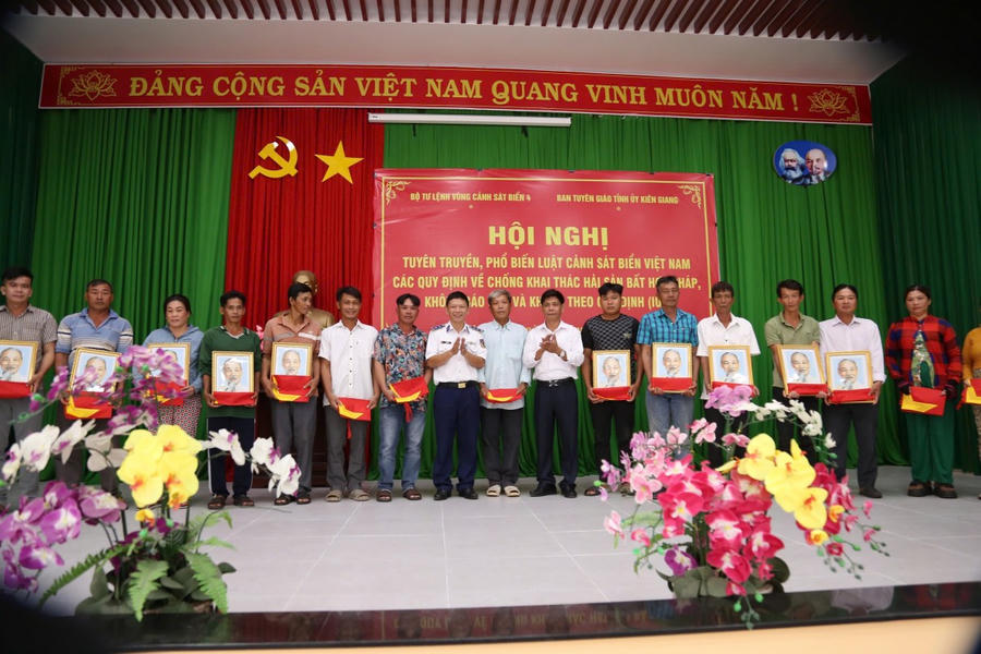 Tặng ảnh Bác Hồ, cờ Tổ quốc và tờ rơi tuyên truyền chống khai thác IUU cho bà con ngư dân tại hội nghị ở Phú Quốc