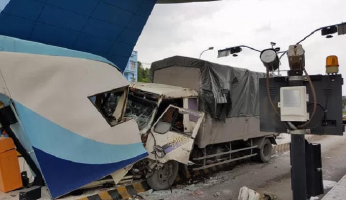 Toàn bộ phần đầu xe tải và cabin trạm thu phí bị biến dạng.