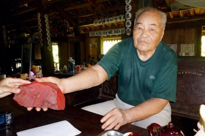 Ông Trương Phúc Chủ khoe viên đá đỏ mà mình giữ lại để làm kỷ niệm.