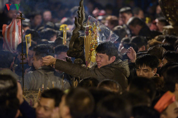 Khổ sở dâng lễ trong đám đông chen chúc nhau.