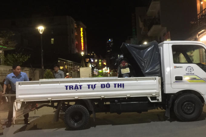 Chiếc xe dừng lại ngược chiều, tại vị trí này có một số người bưng bê một chiếc xe máy lên xe.