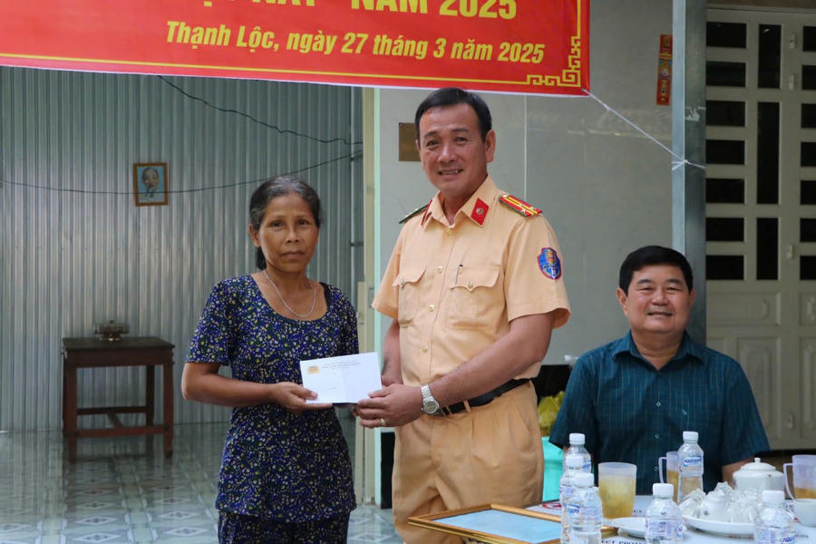 Thượng tá Nguyễn Văn Trường – Trưởng phòng Cảnh sát giao thông, Công an tỉnh Kiên Giang, Tổ trưởng tổ chỉ đạo huyện Giồng Riềng trao quà cho bà Thị Đào