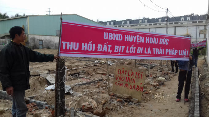 Người dân viết biểu ngữ phản đối việc UBND huyện Hoài Đức thu hồi đất, bán đấu giá, bịt lối đi của người dân.
