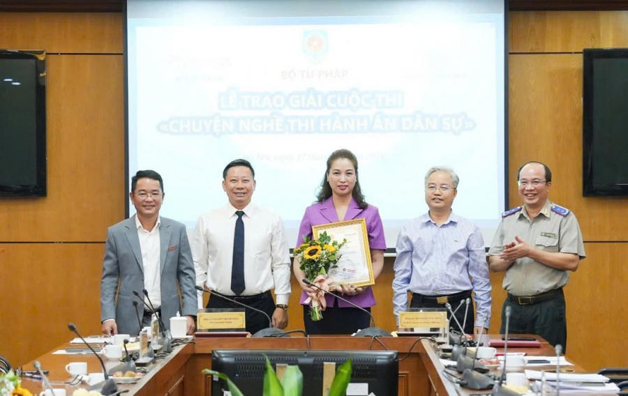 Thứ trưởng Bộ Tư pháp Nguyễn Thanh Ngọc (thứ 2 trái sang), Phó Bí thư chuyên trách Đảng uỷ Bộ Tư pháp Nguyễn Quang Thái ((thứ 4 trái sang), Tổng Biên tập Vũ Hoài Nam (bìa trái) và Cục trưởng Cục Quản lý THADS Nguyễn Thắng Lợi (bìa phải) trao Giải đặc biệt cho tác giả Thu Hằng.