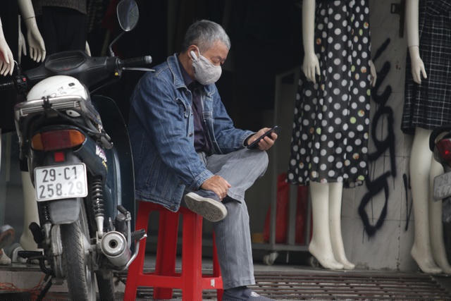 Một nhân viên bảo vệ, kiêm việc ship hàng hoá của một cửa hàng ngồi thảnh thơi.