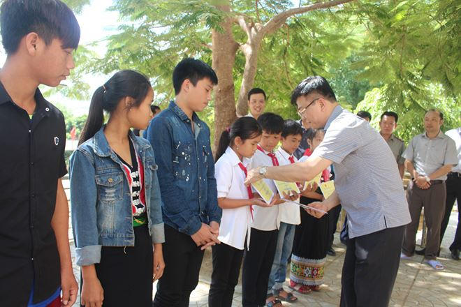 Động viên học sinh vượt khó khăn, nỗ lực học tập, Bộ trưởng đồng thời tặng quà cho các em.