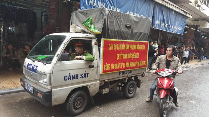 Xe của công an phường đi nhắc nhở các hộ dân tự tháo dỡ, dẹp hàng quán bày bán trên vỉa hè.