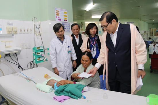Chủ tịch TP Huỳnh Đức Thơ thăm hỏi, động viên các gia đình đang có bệnh nhân nhi chữa trị tại Bệnh viện Phụ sản Nhi Đà Nẵng đêm giao thừa Tết Mậu Thân 2018. Ảnh: Q.Đ.