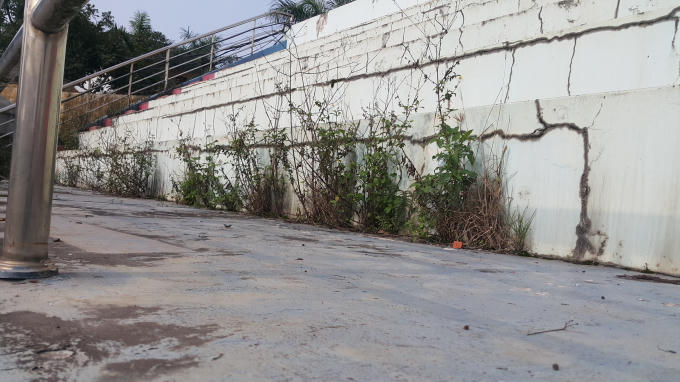 Khán đài cỏ mọc xanh tốt, nhiều chỗ xuất hiện sụt lún, nứt gãy.