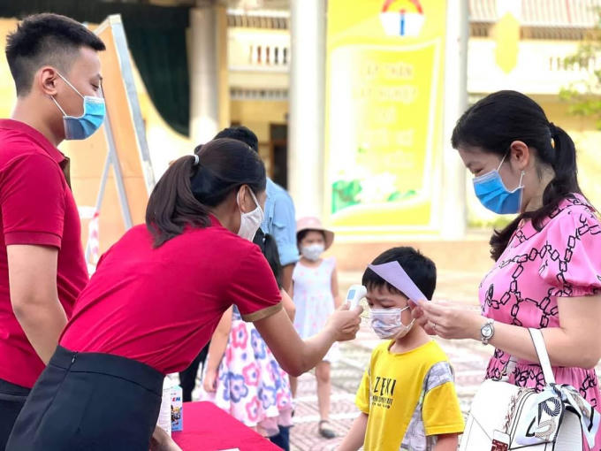 Học sinh trường tiểu học Lê Hồng Phong, quận Ngô Quyền được đo thân nhiệt trước khi vào lớp.