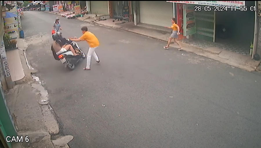 Đôi nam nữ giật điện thoại cháu bé rồi phóng bỏ chạy. Ảnh cắt từ camera.