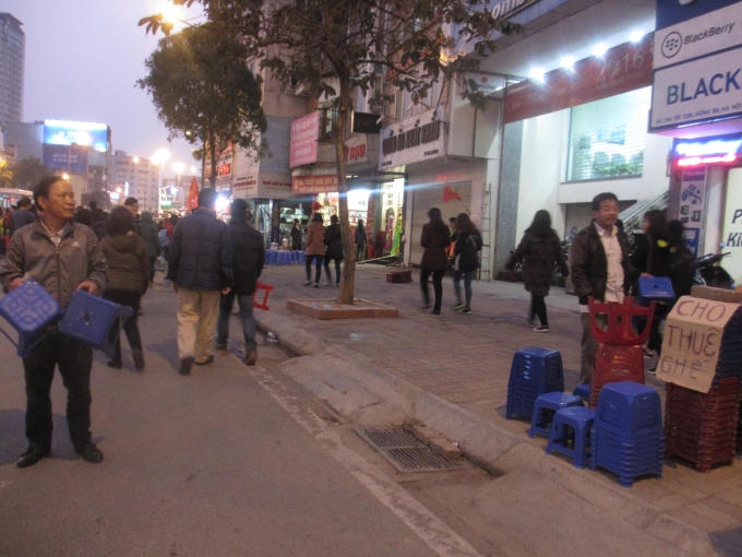 Để phục vụ cho người dân đi làm lễ dâng sao giải hạn, hai người đàn ông này mang ghế ra nhằm cho thuê. (Ảnh: Thu Hường)