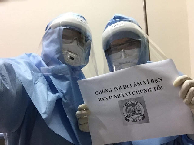 Nam điều dưỡng Đặng Quốc Bảo (phải) cùng đồng nghiệp chụp ảnh với khẩu hiệu