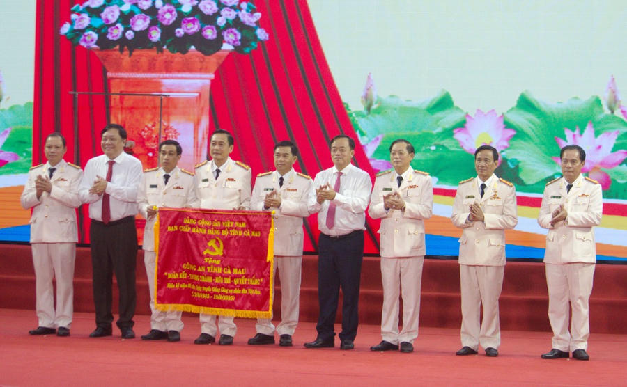 Ông Huỳnh Quốc Việt - Ủy viên dự khuyết BCH TW Đảng, Phó Bí thư Thường trực Tỉnh ủy (bên phải) và ông Phạm Thành Ngại - Phó Bí thư Tỉnh ủy, Chủ tịch UBND tỉnh trao tặng bức trướng của Tỉnh ủy Cà Mau cho Công an tỉnh.