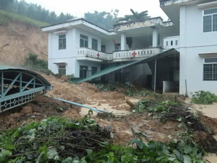 Đất đá sạt từ trên núi xuống vùi lấp mái nhà tại Trạm y tế xã Trà Xinh.