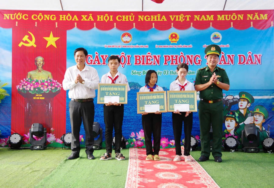 Thiếu tá Trần Thanh Ngoan - Chính trị viên Đồn Biên Sông Đốc và lãnh đạo thị trấn Sông Đốc tặng học bổng cho các cháu học sinh.