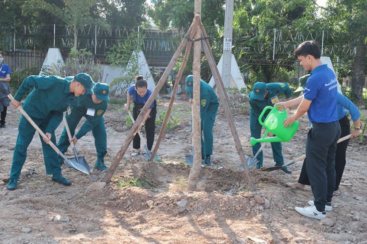 Các lực lượng đoàn viên, dân quân tự vệ tham gia trồng cây. (Ảnh: UBND tỉnh Bình Dương)