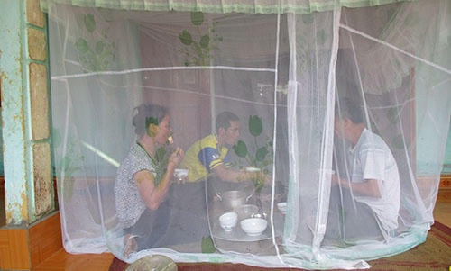 Người dân phải mắc màn ăn cơm vì bãi rác quá gần khiến phát sinh nhiều ruồi nhặng. (Ảnh: Lam Sơn)