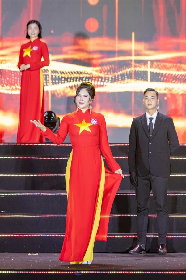 Vẻ đẹp kiêu hãnh, rạng ngời của nữ doanh nhân trong trang phục áo dài truyền thống hoạ tiết cờ Tổ quốc.