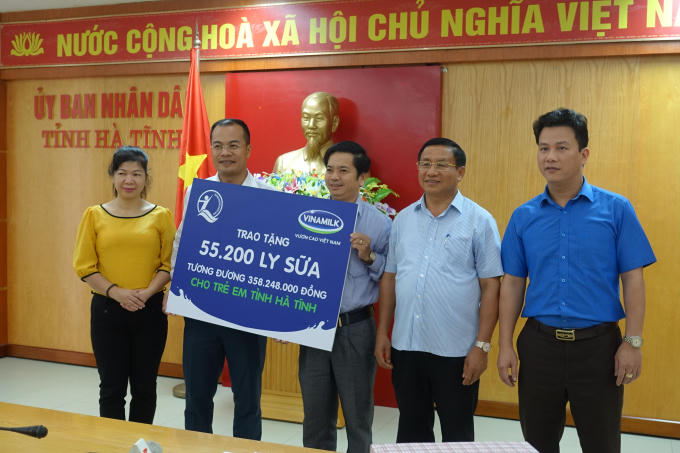 Bà Lê Tuyết Mai, Phó Giám Đốc Quỹ Bảo trợ Trẻ em Việt Nam, ông Đậu Phi Tú – Giám Đốc Trang trại Vinamilk Hà Tĩnh trao bảng tượng trưng 55.200 ly sữa, tương đương 358.248.000 đồng cho trẻ em vùng lũ Hà Tĩnh.