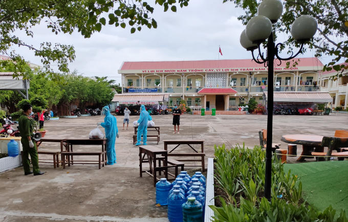 Lực lượng phân phát cơm cho đại diện từng phòng ở điểm cách ly. (Ảnh: Quốc Quý)