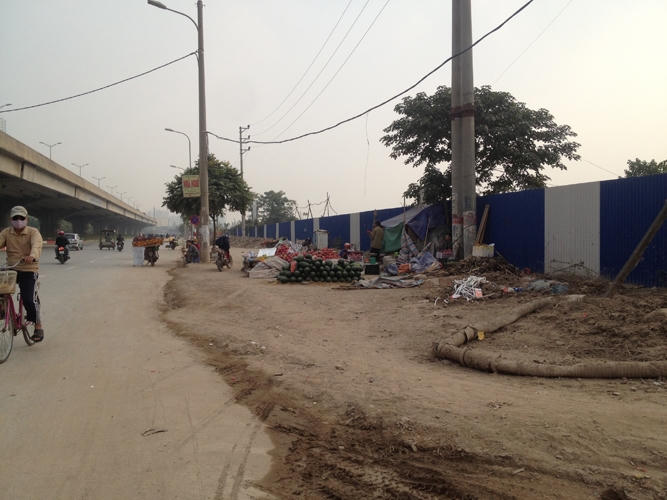 Một đoạn vỉa hè đang được thi công cũng bị tận dụng làm chỗ bày bán hoa quả.