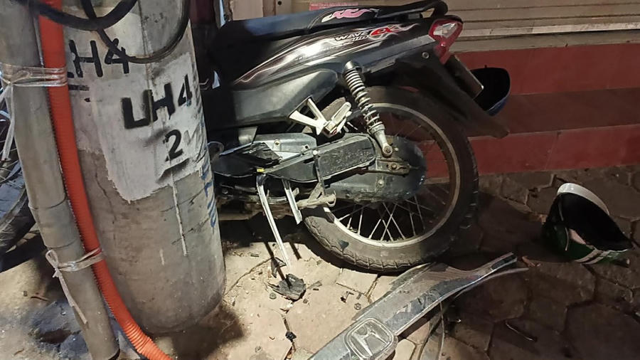 Chiếc xe máy bị đâm vỡ nát và mắc kẹt giữa cột điện.