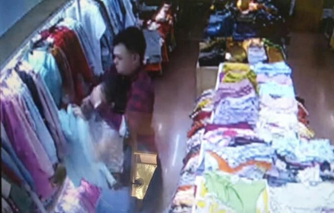 Camera ghi lại hình ảnh Kiên bịt miệng và dùng dao đâm nhân viên bán hàng.
