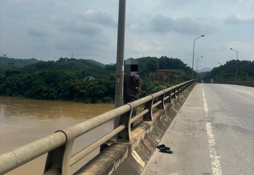 Nam thanh niên đứng ngoài thành cầu có ý định nhảy cầu. (Công an TP Tuyên Quang).