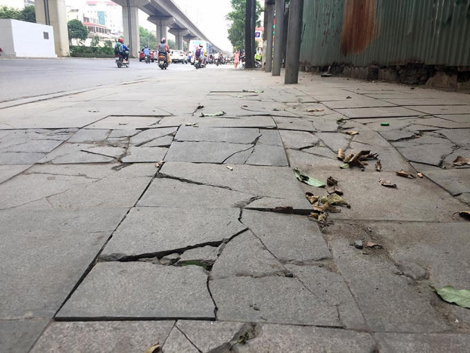 Tại nhiều địa điểm, hàng chục viên đá lát trên vỉa hè đã vỡ, gãy thành nhiều mảnh hoặc cập kênh, gây khó khăn cho người đi bộ