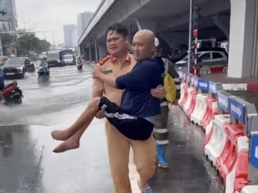 Đại uý Vũ Thanh Sơn bế anh K qua điểm ngập sâu.
