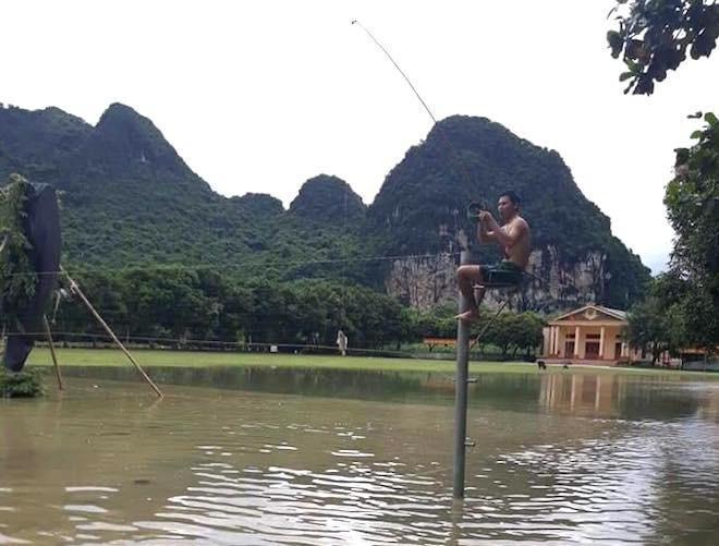 Một người dân ngồi câu cá ngay trên sân bóng chuyền.