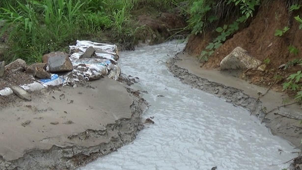 Nước thải xả ra có màu trắng đục, khu vực đất xung quanh miệng ống xả có màu trắng xám, lắng cặn và có mùi nồng khó chịu - Ảnh Huy Trung