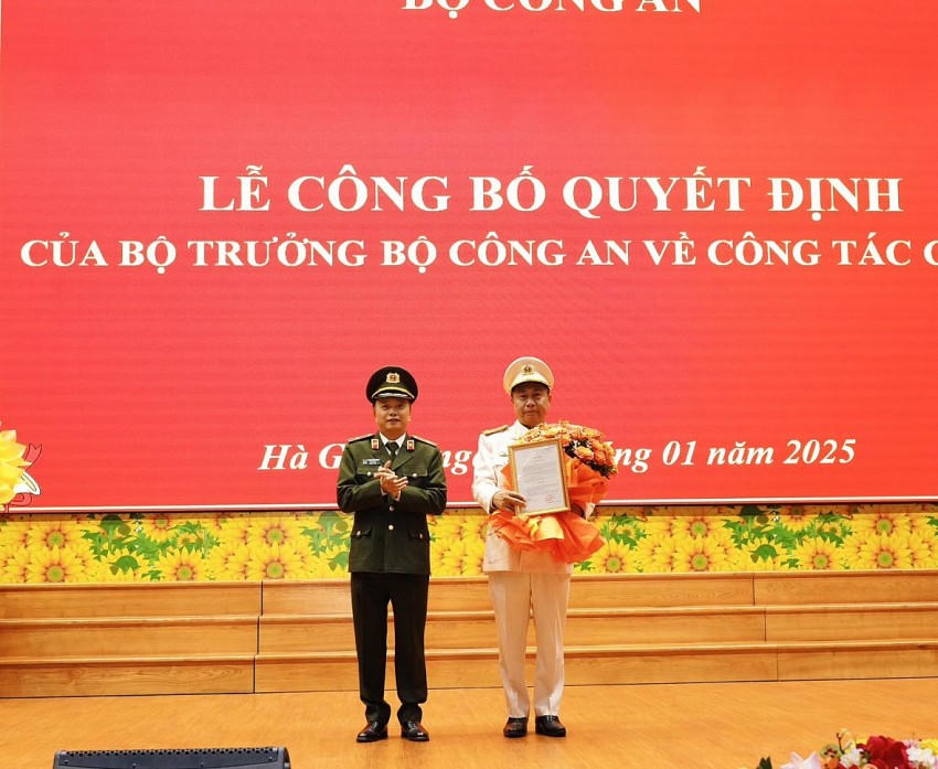 Thiếu tướng Đặng Hồng Đức, Thứ trưởng Bộ Công an trao quyết định và tặng hoa chúc mừng Đại tá Nguyễn Đức Thuận. (Ảnh: Báo CAND).