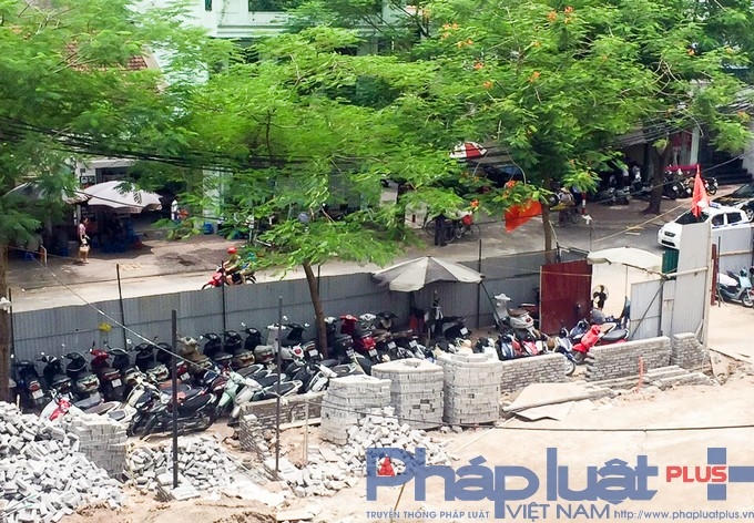 Xe máy được sắp xếp dọc khu vực vỉa hè đã được quây lại bởi tôn và những khu vực khác phía bên ngoài.