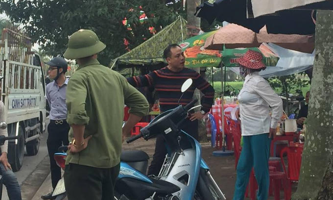 Người phụ nữ được cho là có hành vi bói toán, xin tiền bị lực lượng chức năng đưa ra khỏi khu vực đền Trần.