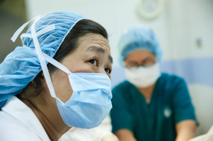Bác sĩ sản khoa căng thẳng theo dõi tình trạng chuyển dạ của bệnh nhân.